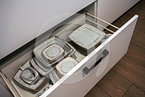 Open kitchen drawer with plates inside, a smart solution for kit