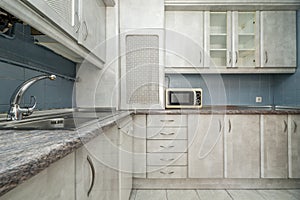 open kitchen with gray wooden cabinets, dressers, cupboards, stainless steel