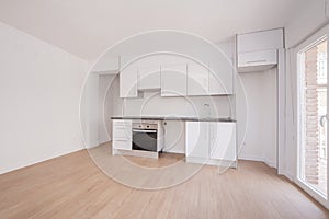 Open kitchen of a newly installed studio apartment that is still missing some appliances