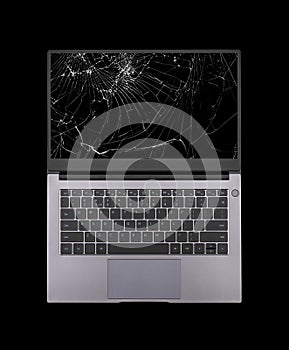 open laptop with a broken, cracked screen isolated on black background