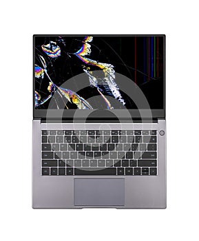 Open laptop with a broken screen in color spots and cracks isolated on white background close up top view.