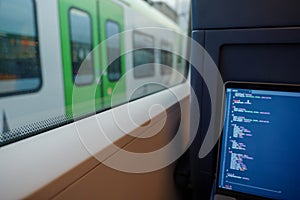 Open laptop or notebook, working as programmer and do some coding on the train during commute.