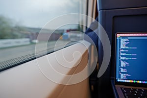 Open laptop or notebook, working as programmer and do some coding on the train during commute.
