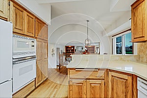 Open large kitchen interior with vaulted ceiling and white appliances