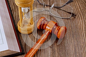 Open law book with a wooden judge's gavel on table in a courtroom or law enforcement office