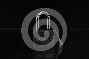 An open lock with the words `success` and a key standing next to it on a black background.