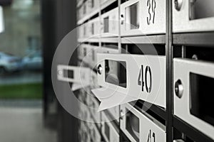 Open mailboxes with keyholes, numbers and receipts in post office, closeup