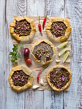 Open meat pies on a black background. Top view.