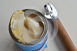 an open metal can of condensed milk is on the table