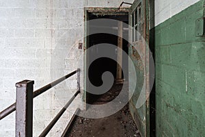Open metal door along pathway into dark abandoned factory