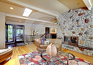 Open modern luxury home interior living room and stone fireplace.