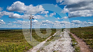 Open mountain landscape with a walking trail in the foreground leading to the horizon.