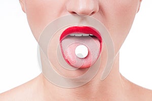 Open mouth holding medicine pill on tongue.