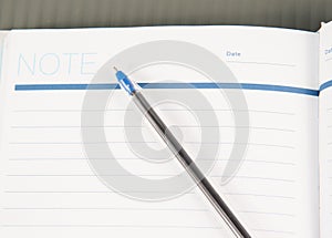 Open note book with lined pages free date space and ballpoint pe