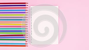 Open notebook appear next to pastel colored pencils. Stop motion