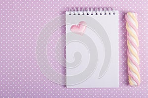 Open notebook with a blank page, marshmallow stick and little valentine