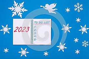 An open notebook diary with the Text 2023 and a TO-DO LIST on a blue background with snowflakes, a white angel