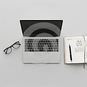 An open notebook displays sketches and notes alongside a black