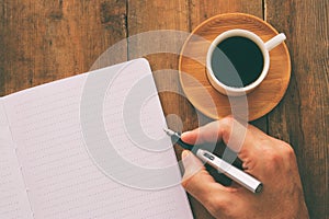 Open notebook with empty pages and other office supplies over wooden old office desk table. Top view, flat lay