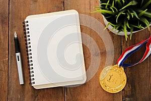 Open notebook with empty pages and other office supplies over wooden old office desk table. Top view, flat lay