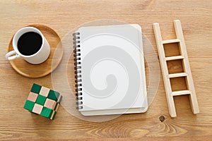 Open notebook with empty pages over wooden old office desk table. Top view, flat lay