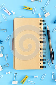 Open notebook on a light blue background. Stationery is in disarray. Beautiful background with place for text. Mock ap.