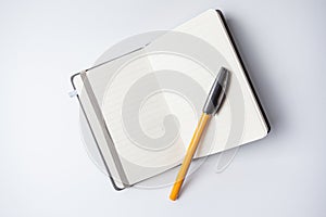 Open notebook with an orange ballpen on it