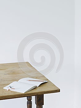 Open notebook with pencil and pencil sharpener on table elevated view