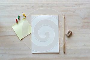 Open notebook and sticky note on wooden background.