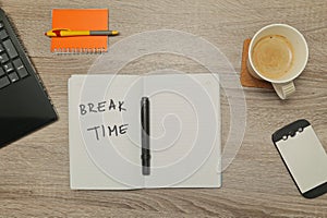 Open notebook with text `BREAK TIME` and a cup of coffee on wooden background.