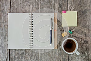 Open notebook on wooden background with coffee cup and yellow no