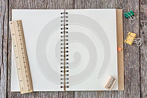 Open notebook on wooden background with wooden ruler.