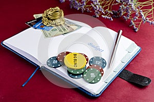 Open notebook with word Budget, poker chips, pen and dollar money. Concept of business, finance and risk