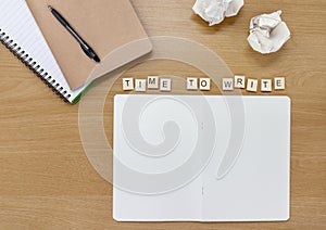 Open notebook on a writer or artists desk, with tiles spelling out `Time To Write`