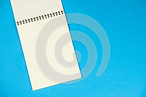 Open notepad on a blue background top view, space for text.