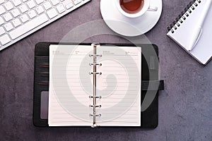 open diary, keyboard and tea on table