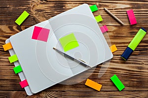 Open notepad with office supplies. Open notepad lies on a wooden desktop with marker, pencil, pen and Stickers
