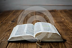 A open old bible on wooden background