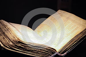 Open old book on a black background