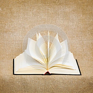 Open old book on brown canvas background