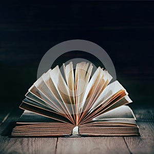 Open old book on dark background, vintage  book with open pages on wooden desk, selective focus