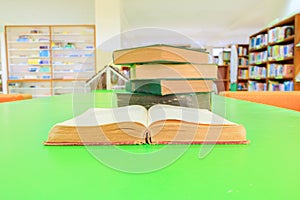 open old book and heap treatise in school library on table green