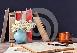 Open old book lying on the wooden table among vintage envelopes. Rustic still life.