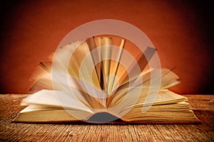 Open old book on a rustic wooden table photo