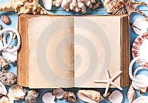 Open old book with seashells around