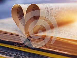 An open old book with sheets in the shape of a heart