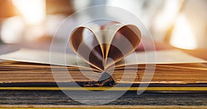 An open old book with sheets in the shape of a heart