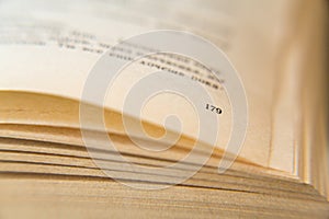 Open old book. Yellowed pages. Page number 179. Paper texture. Macro