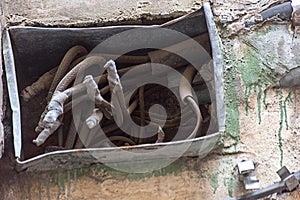 Open old electrical box on a dilapidated wall