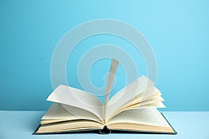 Open old hardcover book on blue background